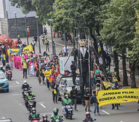 Massa Koalisi Pilih Pulih beserta puluhan masyarakat sipil dan komunitas muda, pelajar serta mahasiswa melakukan aksi karnaval membawa boneka pinokio besar sepanjang jalan Thamrin, Jakarta, Rabu (7/2/2024). Foto: liputan6.com / Angga Yuniar