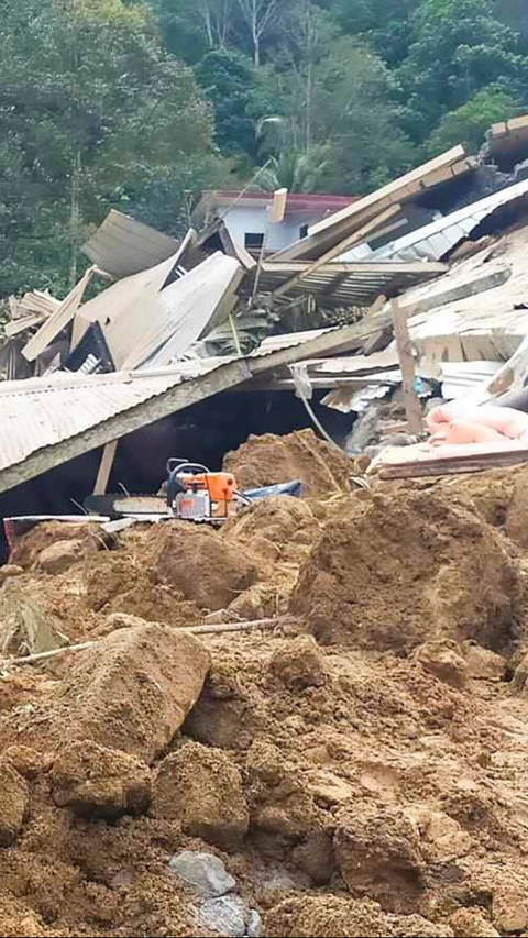 Selain merusak rumah-rumah penduduk, bencana tanah longsor juga dilaporkan telah menimbun dua bus. Foto: AFP / Handout<br>