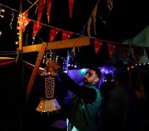 Para pengungsi Palestina di Rafah ini juga saling membantu satu sama lain.<br><br>Selain berbagi makanan dan minuman ketika waktu berbuka puasa, mereka juga saling memberikan dukungan moral. Foto: REUTERS / Mohammed Salem <br>