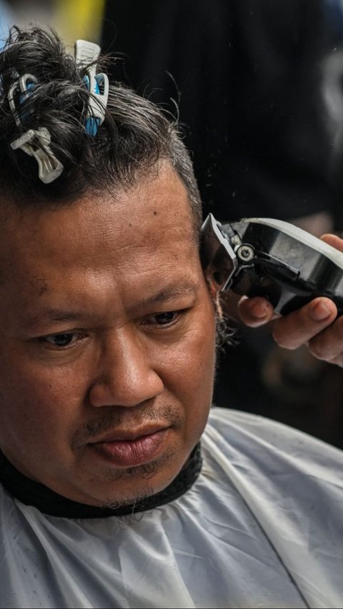 Potong rambut massal ini digelar oleh Komunitas Ngaji Salon. Foto: AFP / Juni Kriswanto<br>