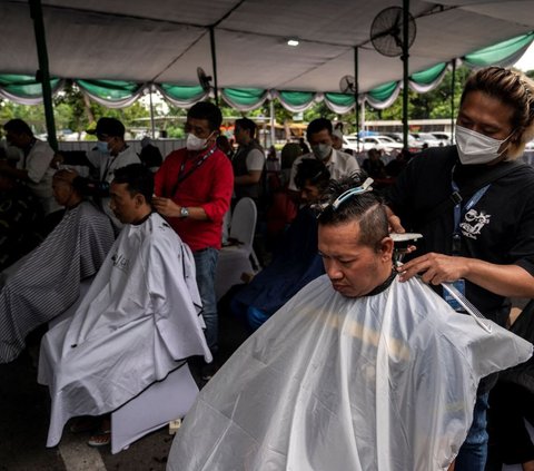 Masyarakat mengikuti potong rambut massal dalam rangka menyambut bulan suci Ramadan di Masjid Al Akbar Surabaya pada 11 Maret 2024. Foto: AFP / Juni Kriswanto