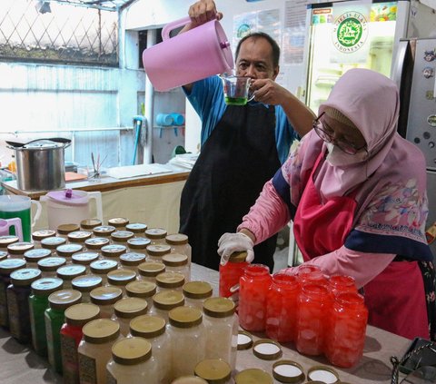 Eny bersama sang suami membuat olahan kolang-kaling di industri rumahan Kolkal Griya  miliknya di Cimanggis, Depok, Jawa Barat, Rabu (13/3/2024). Dalam sehari, Kolkal Griya menghabiskan 60-100 kilogram kolang-kaling untuk diolah menjadi 9 varian rasa. Merdeka.com/Arie Basuki