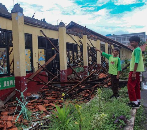 Sejumlah siswa melihat kondisi bangunan SDN Kedaung yang ambruk di kompleks Bappenas, Sawangan, Kota Depok, Jawa Barat, Sabtu (16/3/2024). Ambruknya atap sejumlah ruang kelas pada SDN Kedaung Depok itu terjadi seusai diguyur hujan deras pada Jumat (15/3) kemarin. Merdeka.com/Arie Basuki