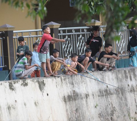 Sejumlah anak memancing ikan di Situ Cicadas, Jakarta, Sabtu (16/3/2024). Memasuki bulan suci Ramadan, situ yang berada di perbatasan Depok dan Jakarta Timur ini semakin ramai dengan kehadiran warga yang memancing ikan. Merdeka.com/Imam Buhori<br>