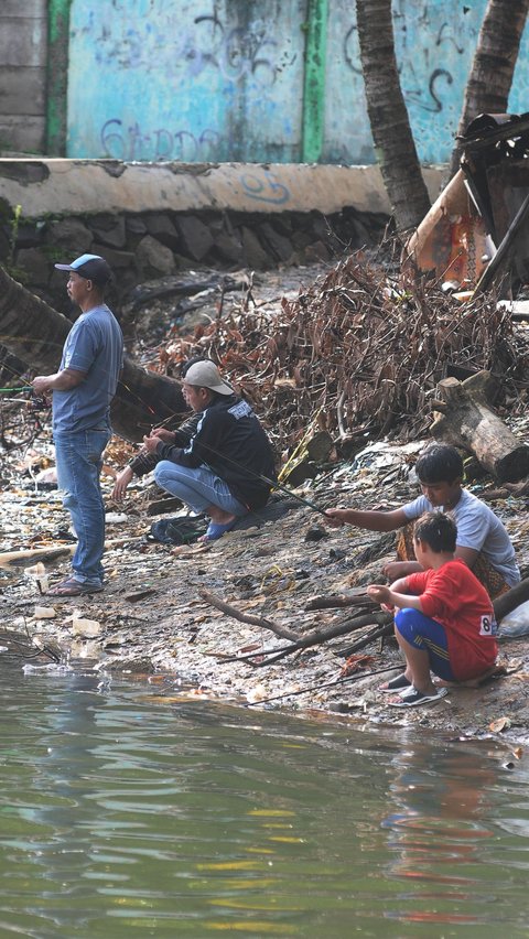Sejumlah anak memancing ikan saat menanti waktu berbuka puasa di Situ Cicadas, Jakarta, Sabtu (16/3/2024). Merdeka.com/Imam Buhori