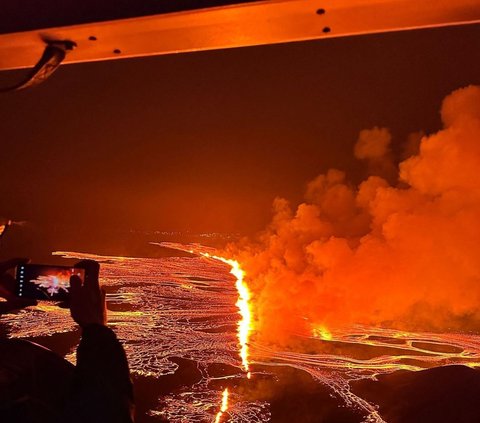 Letusan baru gunung berapi itu juga telah membuat langit berwarna oranye saat lava cair mengalir keluar dari celah di semenanjung Reykjanes. Foto: HANDOUT / Icelandic Coast Guard / AFP