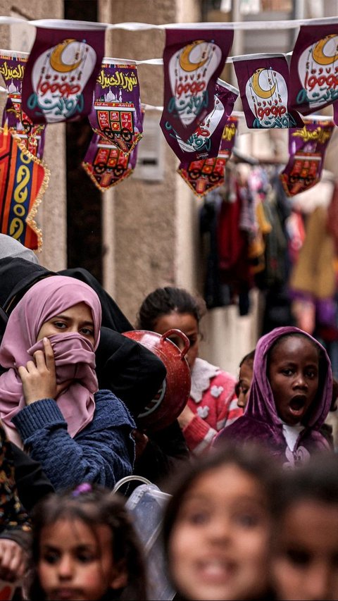 Untuk mendapatkan makanan, mereka harus mengantre panjang. Foto: SAID KHATIB / AFP<br>