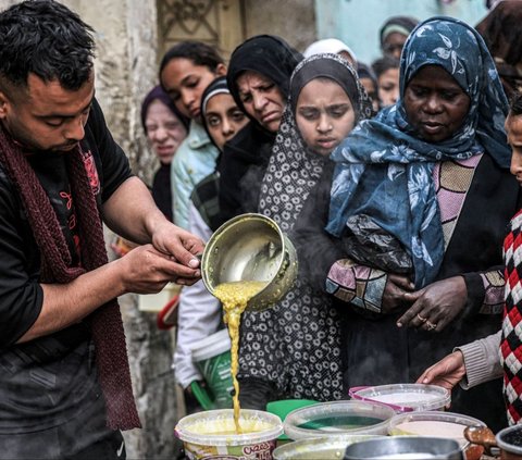 Makanan yang diolah di sebuah dapur umum itu dikelola oleh organisasi amal yang bertugas memasakkan bahan makanan untuk membantu para pengungsi yang akan berbuka puasa selama bulan suci Ramadan, di Rafah. Foto: SAID KHATIB / AFP