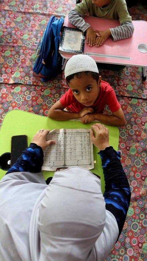 Seorang anak belajar membaca Iqro saat mengikuti pesantren kilat di Ruang Publik Terpadu Ramah Anak (RPTRA) Malinjo. Foto Liputan6.com / Angga Yuniar