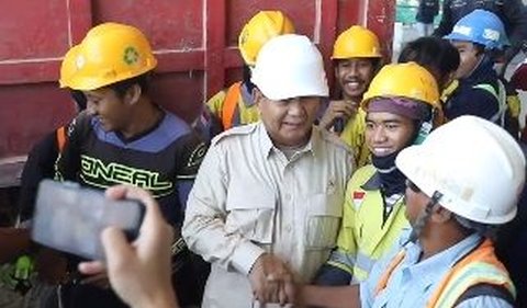 Awalnya, dia melarang seorang pekerja yang berdiri di sebelah kirinya agar tidak berpose dua jari saat foto.