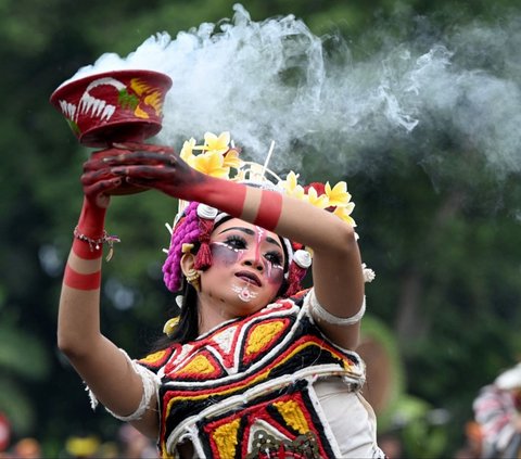 Masyarakat Bali tampil membawakan tarian tadisional saat mengikuti ritual dalam parade patung Ogoh-Ogoh yang melambangkan roh jahat, sebelum perayaan Hari Nyapi digelar di Denpasar, Bali. Foto: AFP / SONNY TUMBELAKA<br>