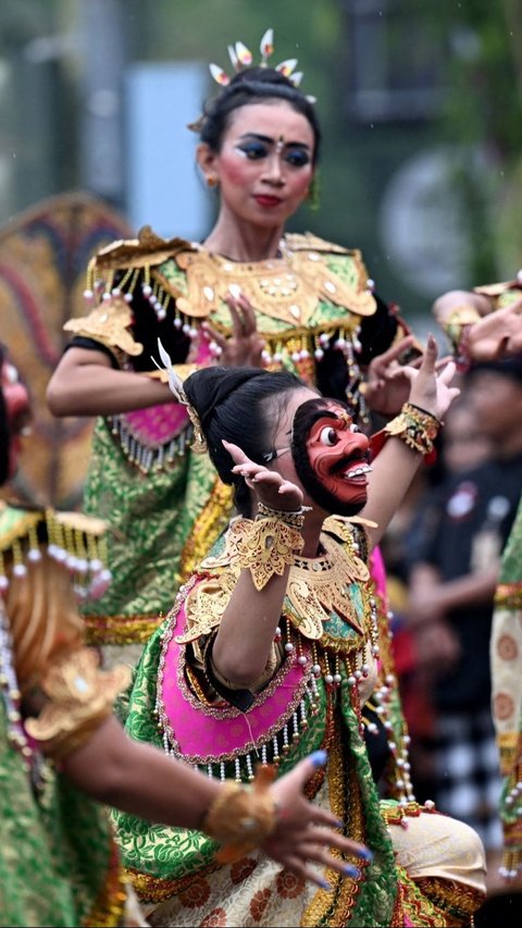 Dalam parade ini, peserta parade tampil dalam balutan baju tradisional hingga mengenakan topeng. Foto: AFP / SONNY TUMBELAKA<br>