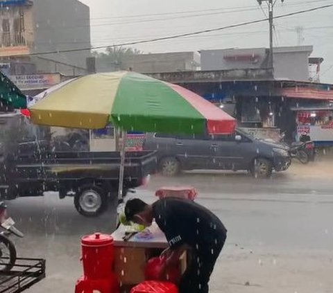 Tetap Dagang Takjil Meski Hujan Deras, Momen Penjual Es Buah Sabar Menanti Pembeli Ini Curi Perhatian