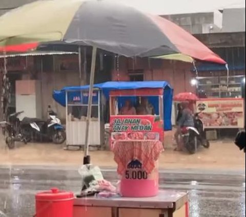 Tetap Dagang Takjil Meski Hujan Deras, Momen Penjual Es Buah Sabar Menanti Pembeli Ini Curi Perhatian