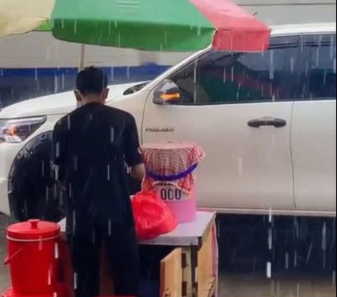 Tetap Dagang Takjil Meski Hujan Deras, Momen Penjual Es Buah Sabar Menanti Pembeli Ini Curi Perhatian