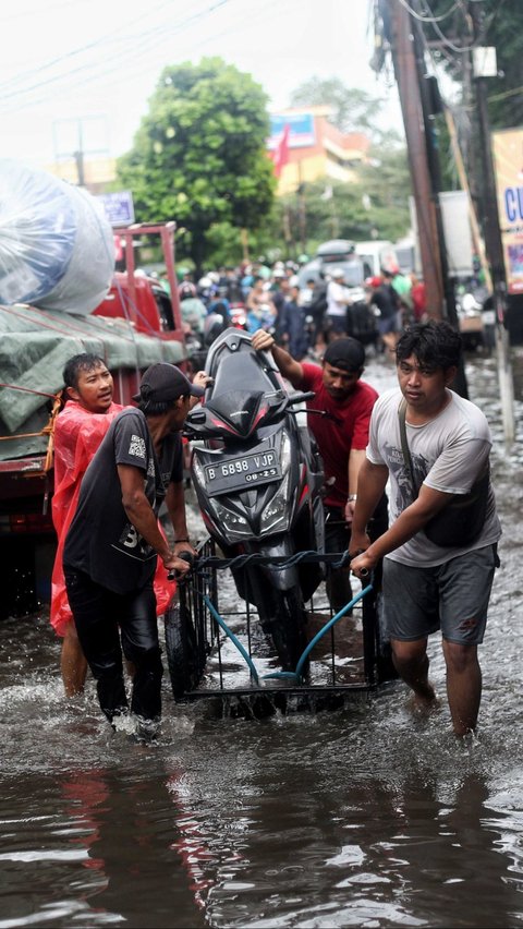 FOTO: Banjir Parah Landa Jalur Penghubung Tangerang-Jakarta, Pemotor Andalkan Jasa Gerobak