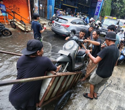 FOTO: Banjir Parah Landa Jalur Penghubung Jakarta-Tangerang, Pemotor Andalkan Jasa Gerobak