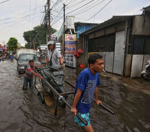 FOTO: Banjir Parah Landa Jalur Penghubung Jakarta-Tangerang, Pemotor Andalkan Jasa Gerobak