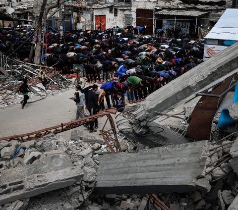 Sejumlah muslim Palestina melaksanakan salat Jumat di dekat reruntuhan Masjid Al Farouq yang hancur seusai dibombardir Israel, Rafah, Jalur Gaza, Jumat (22/3/2024). Hancurnya masjid akibat serangan brutal Israel tak menyurutkan keteguhan muslim Palestina untuk tetap melaksanakan salat berjamaah, terutama saat bulan suci Ramadan. Mohammed Abed/AFP