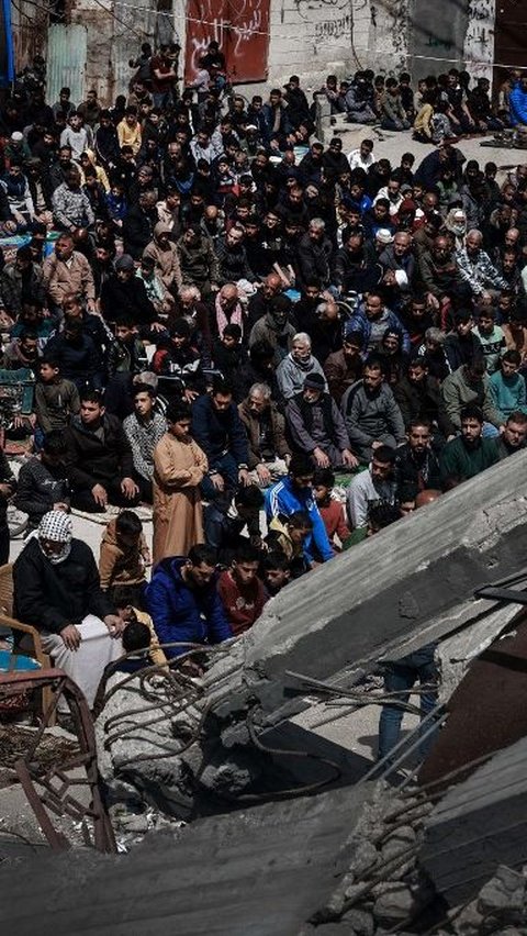 Di Rafah, ribuan warga Palestina tetap melaksanakan salat Jumat meskipun bangunan Masjid Al Farouq telah luluh lantak. Mohammed Abed/AFP