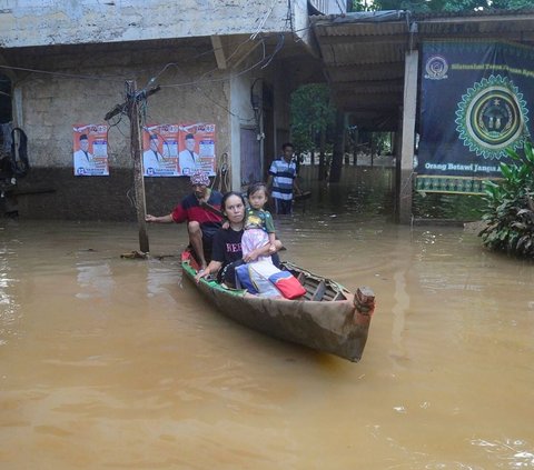 Warga menggunakan perahu saat banjir setinggi sekitar satu meter merendam kawasan Pejaten Timur, Jakarta selatan, Senin (23/03/2024). Foto: merdeka.com / Arie Basuki<br>