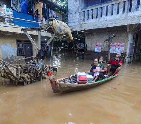 FOTO: Kondisi Ketinggian Banjir di Pejaten Mencapai Satu Meter, Warga Beraktivitas Naik Perahu