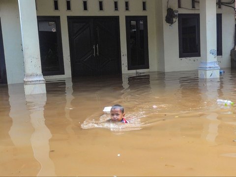 FOTO: Kondisi Ketinggian Banjir di Pejaten Mencapai Satu Meter, Warga Beraktivitas Naik Perahu