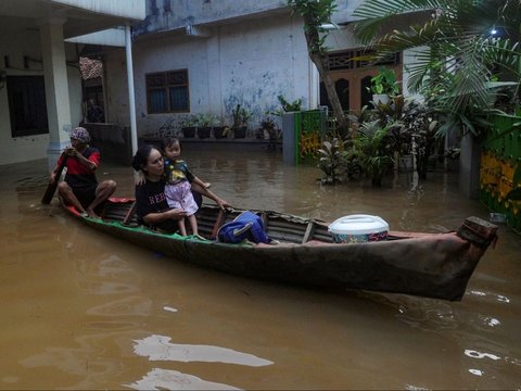 FOTO: Kondisi Ketinggian Banjir di Pejaten Mencapai Satu Meter, Warga Beraktivitas Naik Perahu