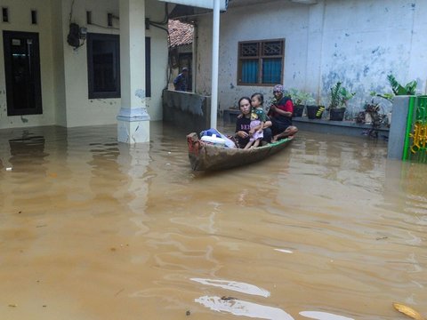 FOTO: Kondisi Ketinggian Banjir di Pejaten Mencapai Satu Meter, Warga Beraktivitas Naik Perahu