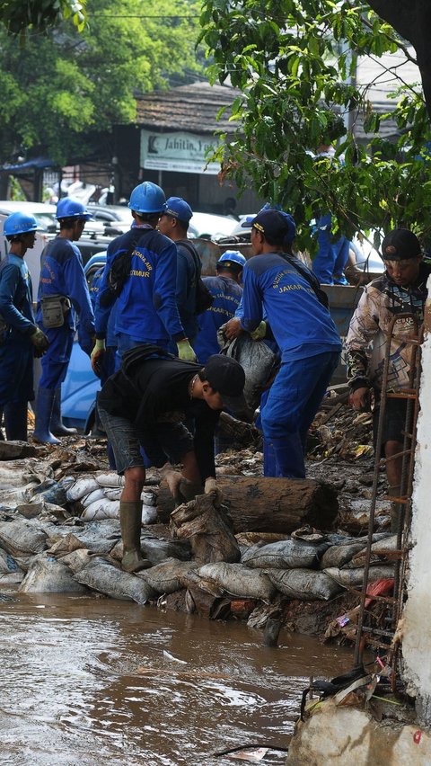 Kini kondisi luapan banjir mulai berangsur surut sehingga membuat petugas dapat bekerja membuat tanggul darurat. Foto: merdeka.com / Imam Buhori