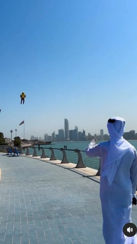 Dalam sebuah unggahan akun noon_uae menampilkan pria berjubah putih berjalan menghampiri kurir yang terlihat terbang menggunakan jetpack.