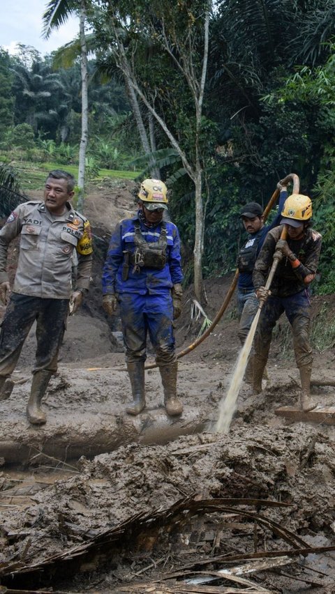 Kondisi ini membuat pencarian dilakukan secara manual dengan melakukan penyemprotan ke material tanah menggunakan air. Foto: TIMUR MATAHARI / AFP<br>