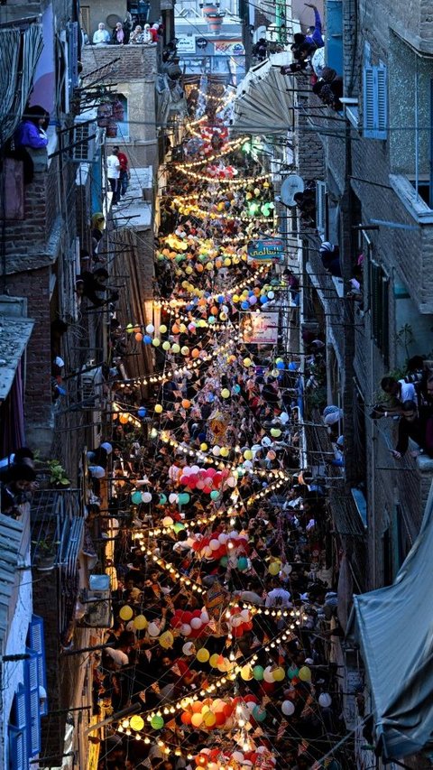 Acara ini tampak meriah karena suasana kota yang dihiasi dengan berbagai lampu, balon-balon, dan dekorasi bendera. Khaled Desouki/AFP