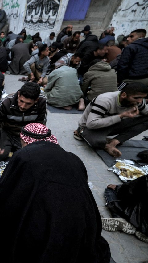 Selama acara berlangsung, suasana terlihat penuh dengan kegembiraan. Hal itu dapat dilihat dari wajah-wajah warga Gaza yang menikmati hidangan buka puasa yang disediakan. Foto: MOHAMMED ABED / AFP