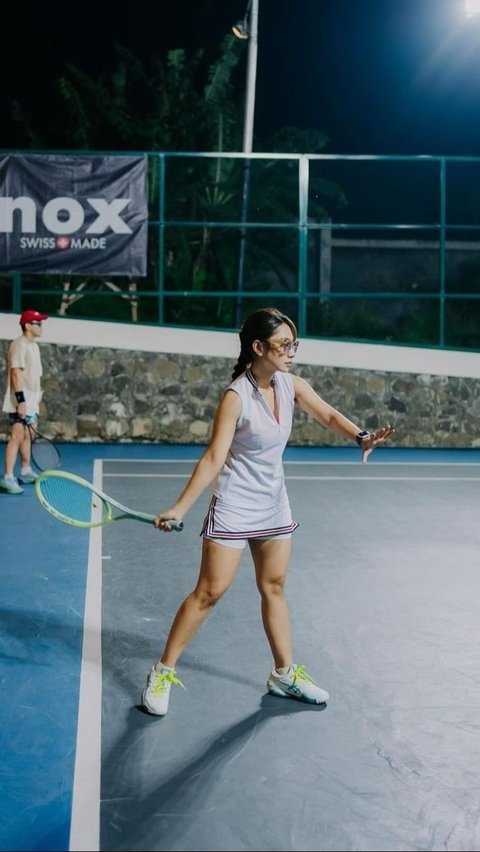 Meski malam hari, Dinda tetap bersemangat bermain tenis.<br>