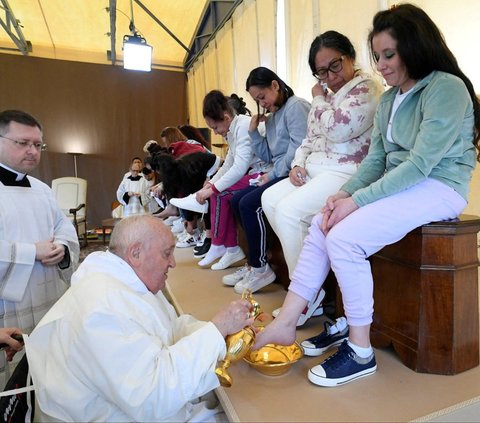 Paus Fransiskus membasuh dan mencium kaki sejumlah narapidana wanita di Penjara Rebibbia, Roma, Italia, pada Kamis (28/3/2024). Ritual membasuh dan mencium kaki narapidana ini dilakukan Paus Fransiskus ketika memimpin Misa Kamis Putih menjelang perayaan Paskah. Vatican Media/­Handout via REUTERS