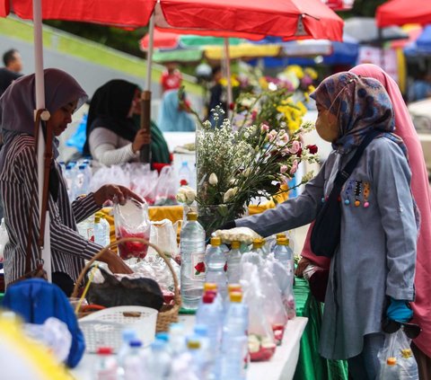 Pedagang bunga tabur melayani pembeli saat berjualan di TPU Karet Bivak, Jakarta, Minggu (3/3/2024). Momen menjelang Ramadan membawa berkah tersendiri bagi pedagang bunga tabur musiman. Liputan6.com/Angga Yuniar<br>