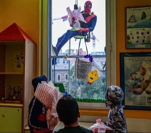 Orang-orang berpakaian seperti 'Spiderman' mengantarkan telur Paskah kepada pasien anak-anak yang dirawat di bangsal anak di Klinik De Marchi, Milan, Italia, pada 28 Maret 2024. Paskah merupakan hari raya bagi umat Nasrani untuk merayakan kepercayaan akan kebangkitan Yesus Kristus. Piero Cruciatti/AFP
