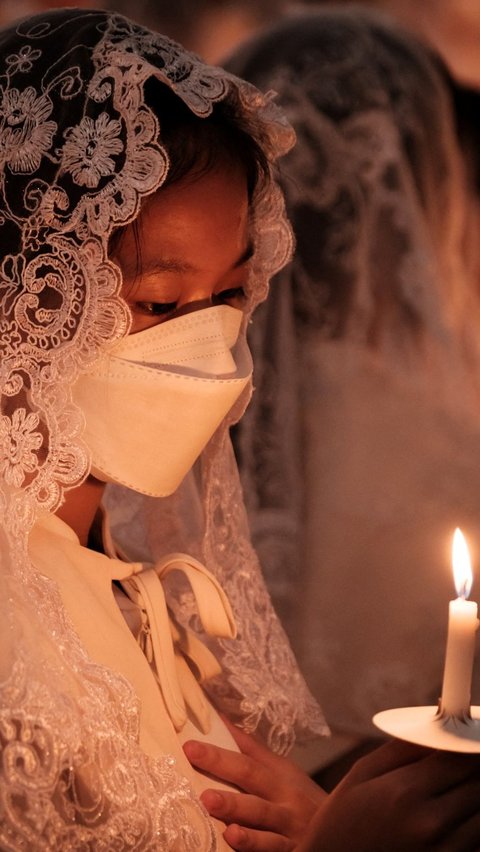 Lilin-lilin itu dinyalakan selama Misa malam Paskah yang berlangsung khidmat di Gereja Santo Kristoforus. Foto: Yasuyoshi CHIBA / AFP