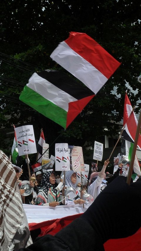 Bendera Indonesia dan Palestinia berkibar selama aksi bela Palestina di depan Kedutaan Besar Mesir, Jakarta, Senin (4/3/2024). Foto merdeka.com / Imam Buhori