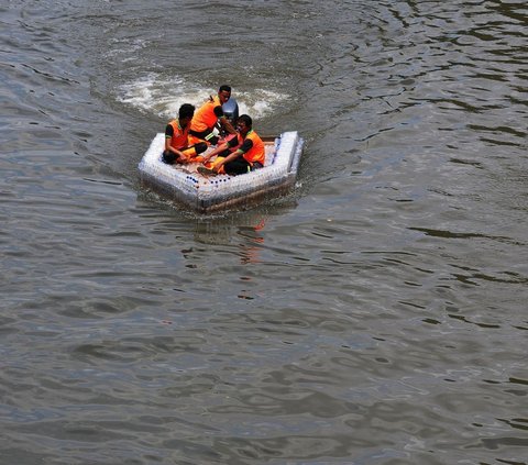 Petugas UPS Badan Air melakukan uji coba terhadap ketahanan dan keseimbangan perahu yang terbuat dari botol plastik bekas di aliran Kanal Banjir Timur (KBT), Jakarta, Selasa (5/3/2024). Foto: merdeka.com / Imam Buhori