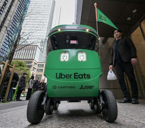 Robot pengantar makanan dari Uber Eats saat mengantarkan pesanan kepada pelanggan ketika diuji coba di Tokyo, Jepang, pada 5 Maret 2024. Richard A. Brooks/AFP