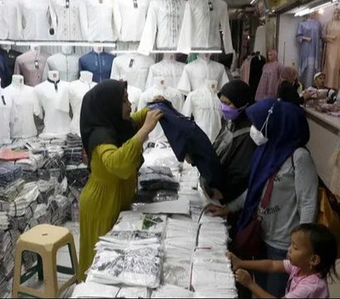 Pedagang membantu calon pembeli memilih busana di Pasar Tanah Abang Blok A, Jakarta, Rabu (6/3/2024). Menjelang Ramadan, aktivitas jual beli di Pasar Tanah Abang mulai mengalami peningkatan. Liputan6.com/Herman Zakharia