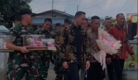 Di sebelahnya, berjalan seorang pria menggunakan batik yang diduga merupakan sang komandan.