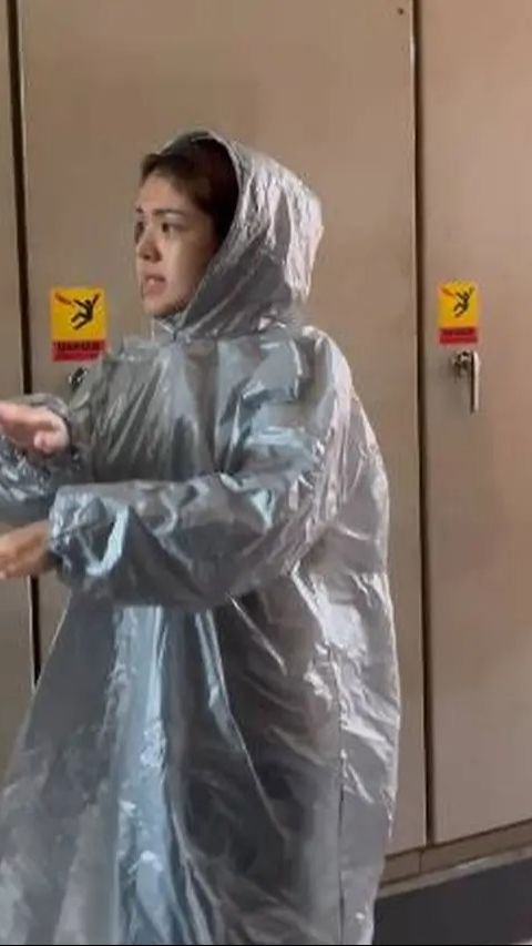 Dengan kondisi hujan, Tina Toon tetap semangat meninjau lokasi banjir sambil mengenakan mantel kresek.<br>