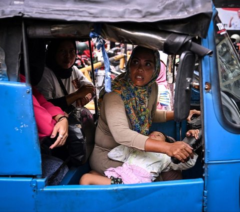 Bersama putrinya yang berusia tiga tahun, Ekawati mengarungi lalu lintas Jakarta yang terkenal buruk sebagai sopir bajaj demi mencari nafkah. Ekawati merupakan salah satu dari semakin banyak perempuan Indonesia yang mencari pekerjaan informal di luar rumah. Adek Berry/AFP