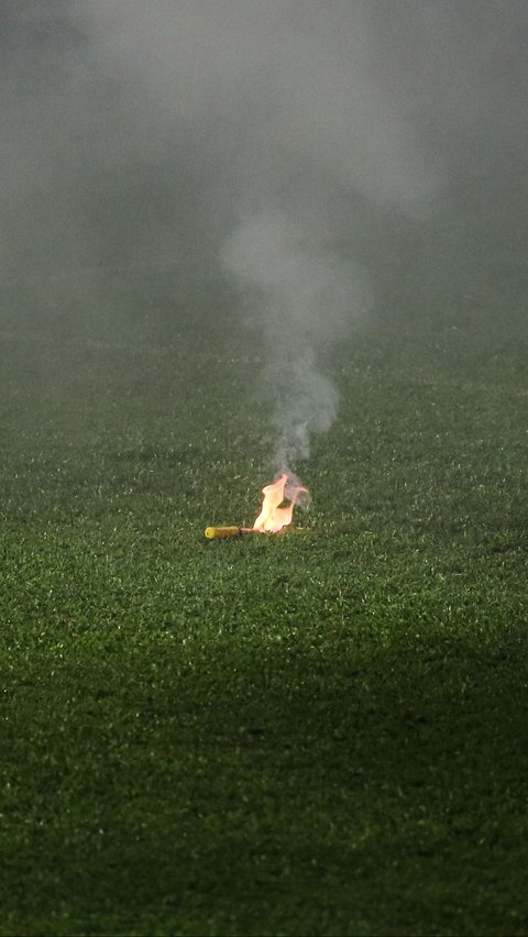 Penampakan sebuah flare yang terbakar di tengah lapangan hijau. Bola.com/Bagaskara Lazuardi