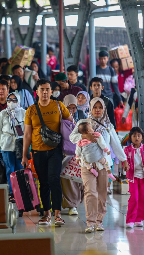 Dengan membawa banyak barang bawaannya, para penumpang berjalan kaki menuju pintu keluar Stasiun Senen. Foto: Liputan6.com / Angga Yuniar