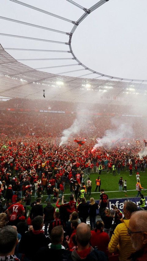 Keberhasilan Bayer Leverkusen mengunci gelar juara Bundesliga musim ini disambut suka cita oleh suporter yang memenuhi Stadion BayArena, Leverkusen. Foto: REUTERS/Wolfgang Rattay
