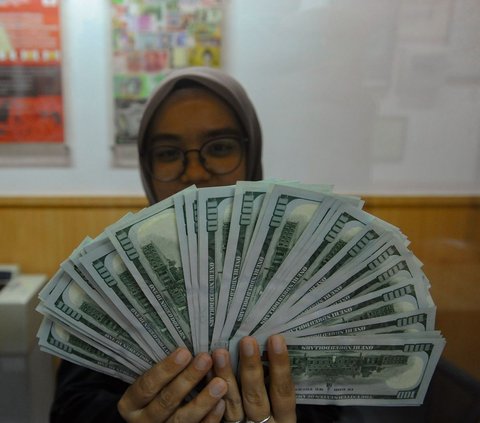 Petugas valas menunjukkan lembaran uang dolar Amerika Serikat di Dolar Asia Valas di kawasan BSD, Tangerang Selatan, Banten, Rabu (16/4/2024). Nilai tukar rupiah terhadap dolar Amerika Serikat terus mengalami pelemahan seusai libur panjang Lebaran. Merdeka.com/Arie Basuki<br>